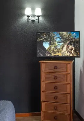a tv on top of a dresser in a bedroom at Hostal Victoria in Altura
