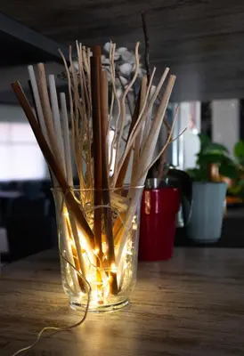 a glass vase filled with sticks and lights on a table at Hostal Victoria in Altura