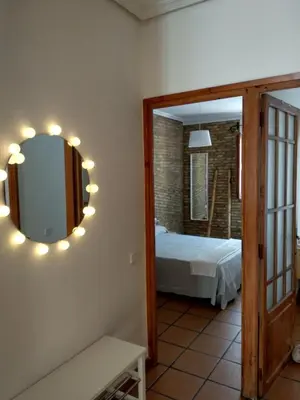 a bedroom with a mirror and a bed in a room at Apartamento con estilo in Valencia