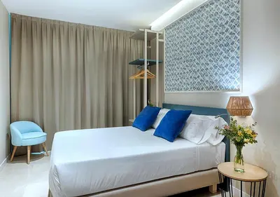 a bedroom with a white bed with blue pillows at Opera House Valencia B&B in Valencia