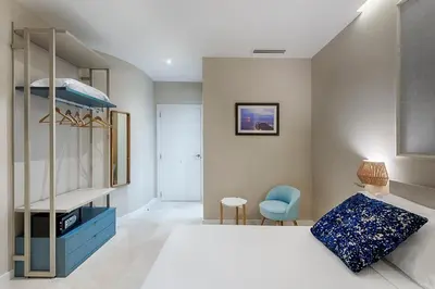a bedroom with a white bed and a blue chair at Opera House Valencia B&B in Valencia