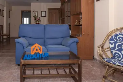 a living room with a blue couch and a table at Mar y Montaña, 2º-18 in Cullera
