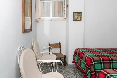 a room with two chairs and a bed and a window at Estrella, 2º-10 in Cullera