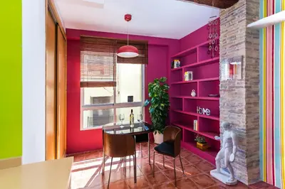 a dining room with pink walls and a table and chairs at Fun&Happy VLC Center in Valencia