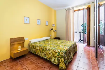 a bedroom with a bed with a yellow wall at Fun&Happy VLC Center in Valencia
