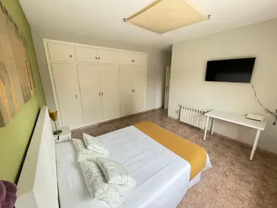 a bedroom with a bed and a desk and a television at Casa Maica in Lliria
