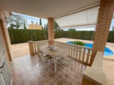 a patio with a table and chairs and a pool at Casa Maica in Lliria