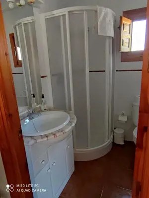 a white bathroom with a sink and a shower at La Rueda Apartamentos Rurales in Chulilla