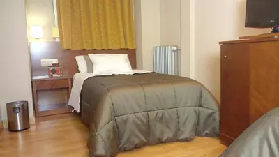 a bedroom with a bed and a television in it at Hotel Avenida in Requena