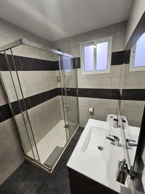 a bathroom with a glass shower and a sink at Apartamentos Turia in Valencia
