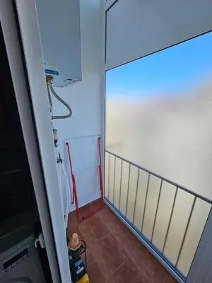 a bathroom with a white refrigerator with a red hose at Apartamentos Turia in Valencia