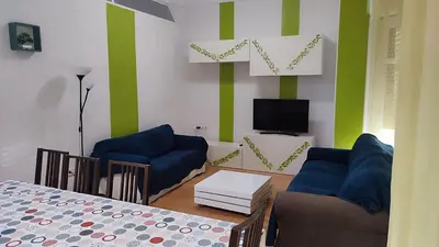 a dining room with a table and a living room at Apartamentos Turia in Valencia