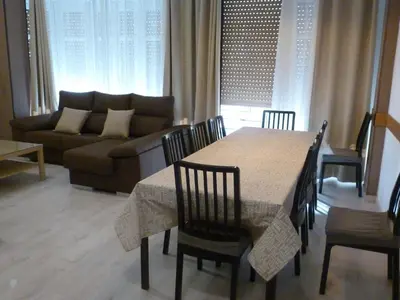 a living room with a table and a couch at Apartamentos Turia in Valencia