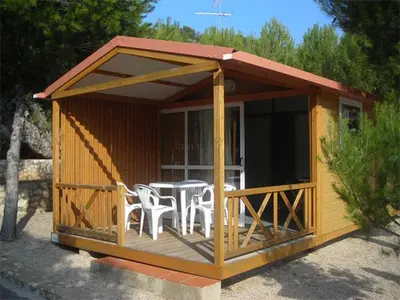 a cabin with a table and chairs on a deck at Camping Santamarta in Cullera
