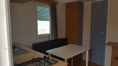a kitchen with a stove and a table and a window at Camping Santamarta in Cullera