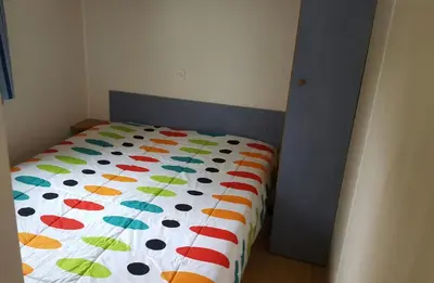a bed with a colorful comforter in a bedroom at Camping Santamarta in Cullera