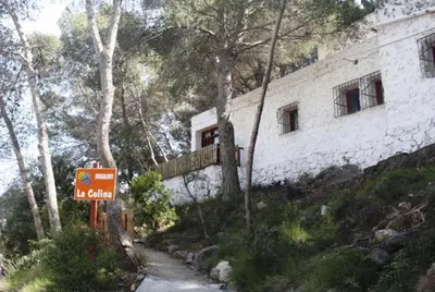 a building on a hill with a sign in front of it at Camping Santamarta in Cullera