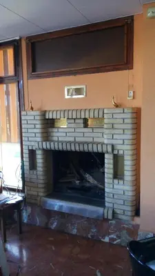 a brick fireplace in a living room with a window at Hotel-Motel Sol II in Requena