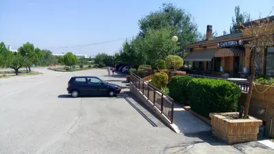a small car parked in a parking lot next to a building at Hotel-Motel Sol II in Requena