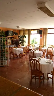 a dining room with white tables and wooden chairs at Hotel-Motel Sol II in Requena