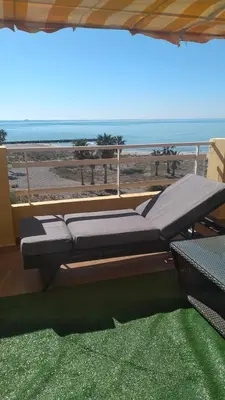 a couch sitting on top of a balcony with a beach at Atico Duplex 1ª in Xilxes