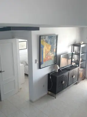 a living room with a painting on the wall at Atico Duplex 1ª in Xilxes