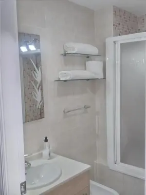 a bathroom with a sink and a shower and a mirror at Atico Duplex 1ª in Xilxes