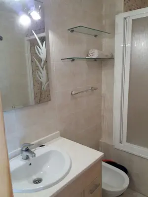 a bathroom with a sink and a toilet and a mirror at Atico Duplex 1ª in Xilxes