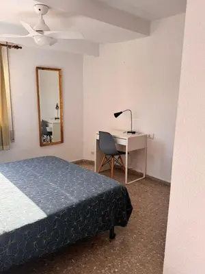 a bedroom with a bed and a desk and a mirror at Casa De La Luz in Valencia