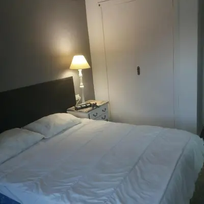 a bedroom with a white bed with a lamp and a dresser at Casa De La Luz in Valencia
