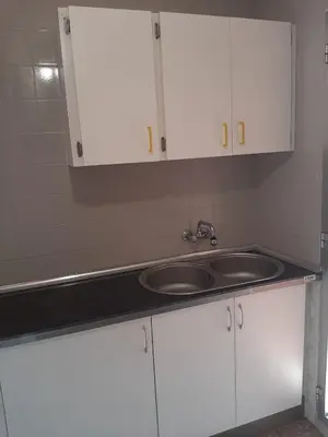 a kitchen with a sink and white cabinets at Casa De La Luz in Valencia