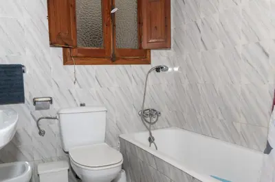 a bathroom with a toilet and a bath tub at La Ponderosa, 4º-21 in Cullera