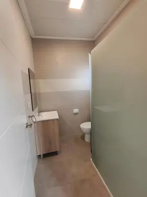 a bathroom with a toilet and a sink and a door at Camping Barraquetes in Sueca