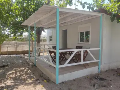 a pavilion with a table and chairs under it at Camping Barraquetes in Sueca