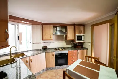 a kitchen with wooden cabinets and a stove top oven at Awesome apartment center Valencia in Valencia