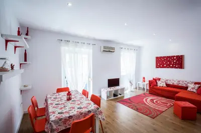 a living room with a red couch and a table at El Coral Apartment Valencia in Valencia