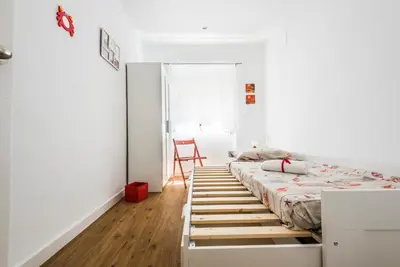 a bedroom with a bed and a chair in it at El Coral Apartment Valencia in Valencia
