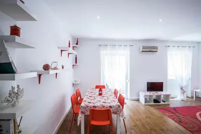 a dining room with a table and red chairs at El Coral Apartment Valencia in Valencia