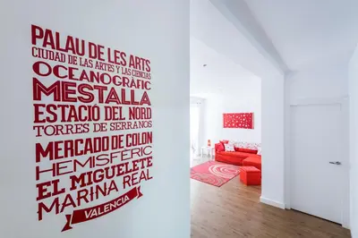 a living room with a red couch and a wall with a mural at El Coral Apartment Valencia in Valencia
