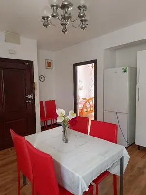 a dining room table with red chairs and a vase of flowers at Burriana in Burriana