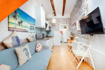 a living room with a blue couch and a kitchen at La casita azul de la playa in Valencia