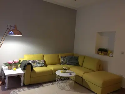 a living room with a yellow couch and a table at Malvarrosa Calle Pavia in Valencia