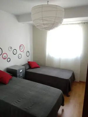 a bedroom with two beds and a large chandelier at Apartamento en la Ciudad de las Artes y las Ciencias in Valencia