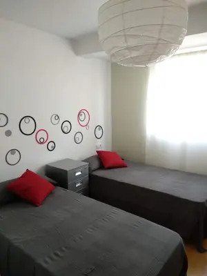 a bedroom with two beds and a large chandelier at Apartamento en la Ciudad de las Artes y las Ciencias in Valencia