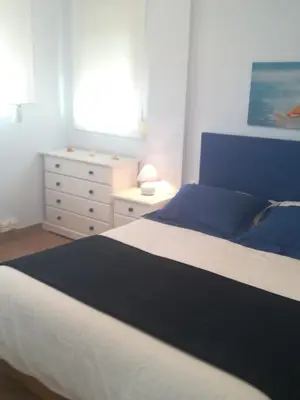 a bedroom with a blue and white bed and a dresser at apartamento junto al mar in Cullera