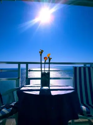 a table with a vase with flowers on it at apartamento junto al mar in Cullera