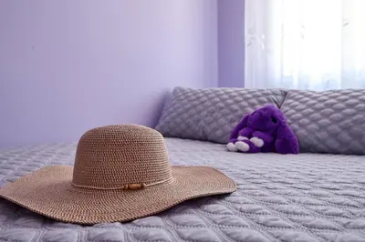 a hat and a purple teddy bear on a bed at Casa En La Playa Del Rey in Mareny Barraquetas