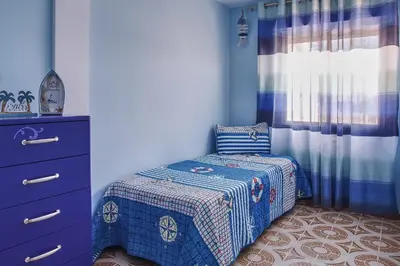 a small bedroom with a bed and a dresser at Casa En La Playa Del Rey in Mareny Barraquetas