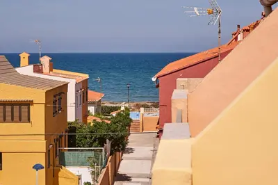 an alley between buildings with the ocean in the background at Casa En La Playa Del Rey in Mareny Barraquetas