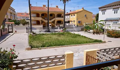 a house with a garden in the middle of a street at Casa En La Playa Del Rey in Mareny Barraquetas